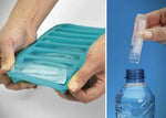 Teal silicone ice cube tray being used to extract ice cubes from a bottle.